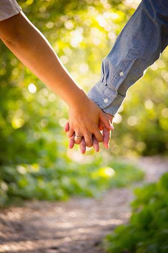holding hands shallow focus photo of man and woman holding hands love